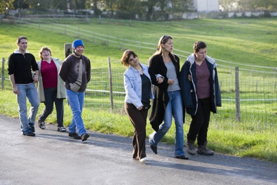 Sabine, far right, walking arm in arm with her caregiver and housemates 
Photo: Film Movement